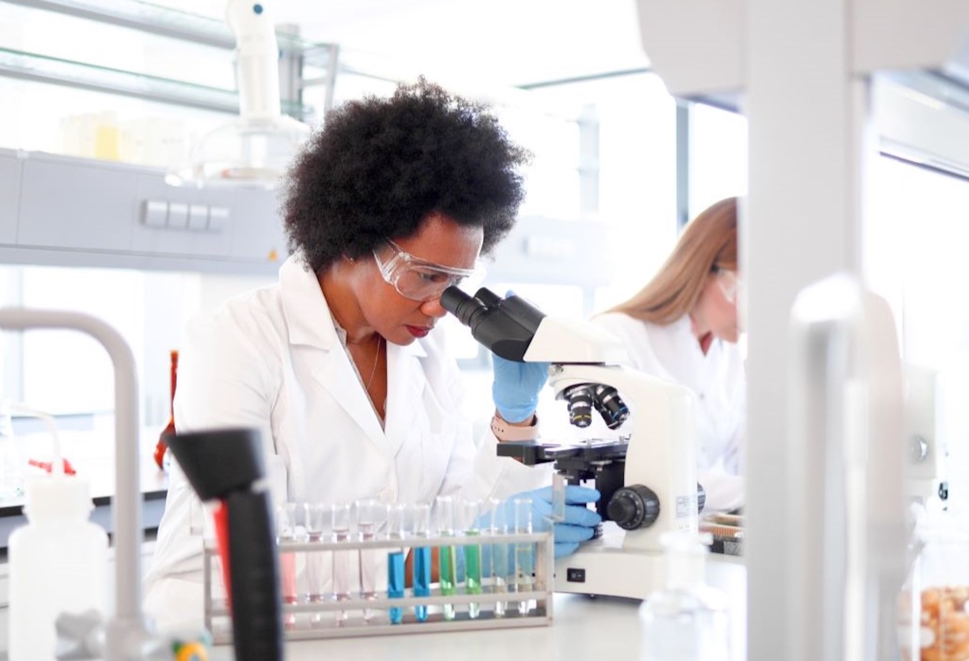 Idox Lilie Sexual Health Software HIV Patient Management Module Two Members of Clinical Laboratory Team with microscopes and test equipment