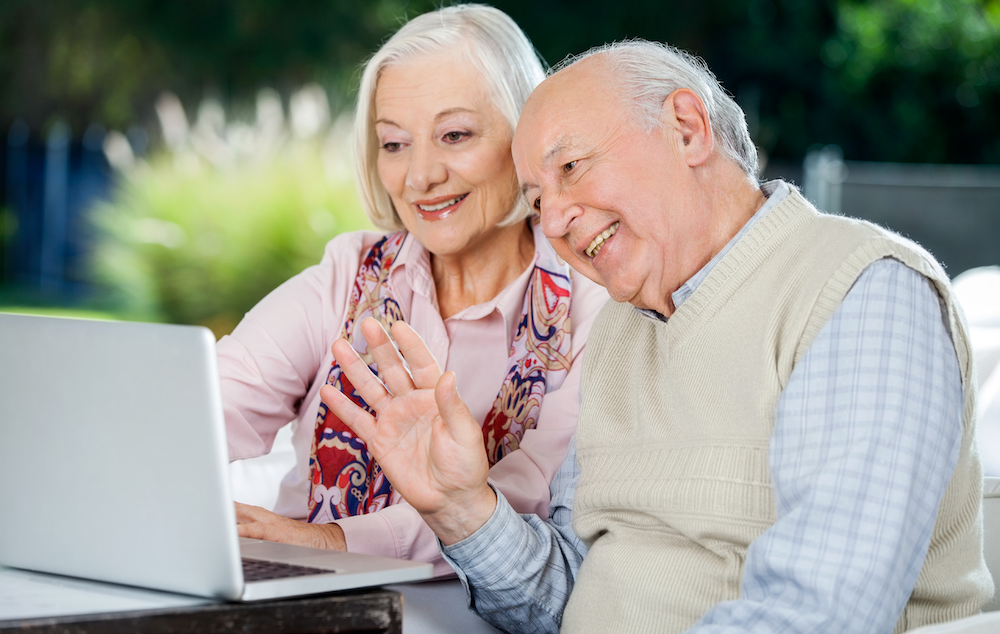 Where-to-find-the-money Housing association, elderly couple smiling looking at laptop