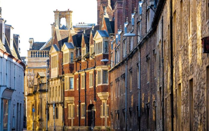 Sunny day view of Cambridge, England, showing historic university buildings and the River Cam with trees and riverside scenery