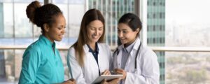 Three nurses using a tablet to manage patient information within Gloucestershire sexual health services