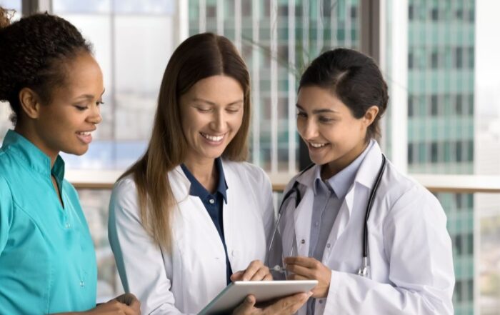 Three nurses using a tablet to manage patient information within Gloucestershire sexual health services