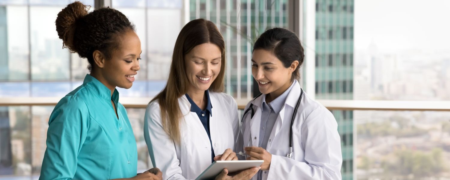 Three nurses using a tablet to manage patient information within Gloucestershire sexual health services