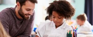 EHC Hub teacher providing one-to-one support to a primary school pupil in a classroom, representing SEND education.